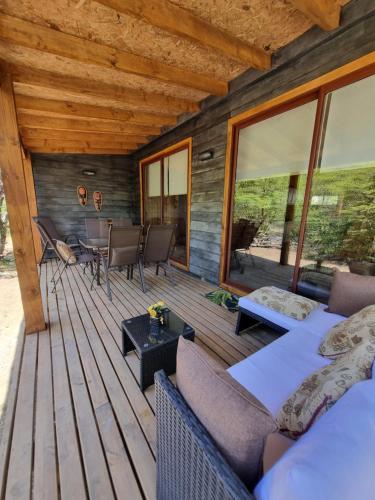 a wooden deck with a couch and a table at Ruka Lee II Las Trancas - Refugios de Montaña Reloncaví - Factura Inmediata in Nevados de Chillan