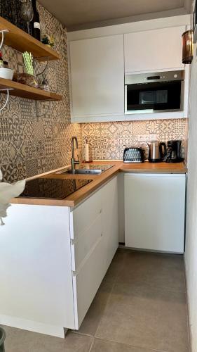 a kitchen with white cabinets and a sink at Atlantic View Maspalomas in Maspalomas