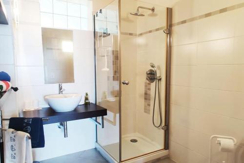 uma casa de banho com um lavatório e uma cabina de duche em vidro. em Bel appartement climatisé vue mer parking gratuit. em Villefranche-sur-Mer