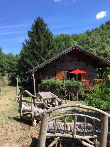una cabaña de madera con un banco delante en Chalet de charme, en Montfort-sur-Boulzane