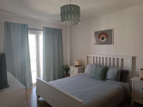 1 dormitorio con cama blanca y almohadas azules en Vivienda Vacacional La Galana, en Corralejo