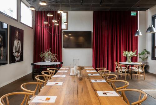 a large wooden table in a room with red curtains at Pereh Mountain Resort in Gadot