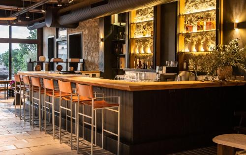 a bar in a restaurant with orange stools at Pereh Mountain Resort in Gadot