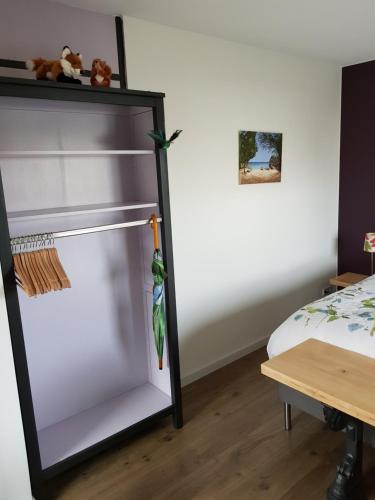 um frigorífico de vidro num quarto ao lado de uma cama em Casa Paz em Elst