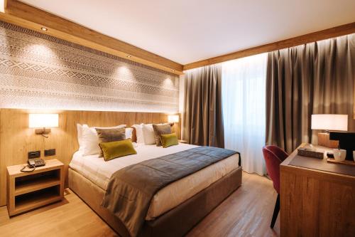 um quarto de hotel com uma cama e uma secretária em Valtur Cristallo Ski Resort, Dependance Cristallino em Breuil-Cervinia