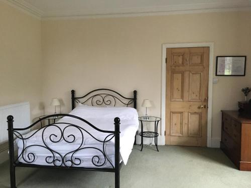a bedroom with a bed and a wooden door at Furtho Manor Farm in Milton Keynes