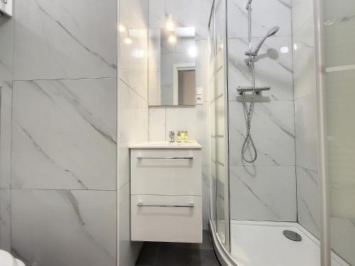 uma casa de banho branca com um chuveiro e um lavatório. em Nestor&Jeeves - GOLDIE FRANCE RIVIERA - Very close sea em Nice