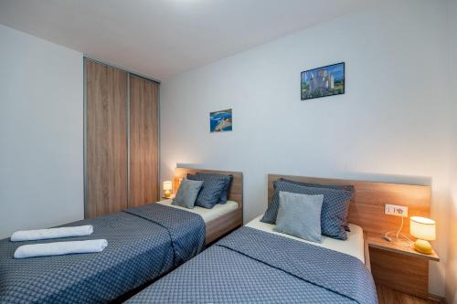 Holiday Home Aria في نين: سريرين في غرفة باللون الأزرق والأبيض