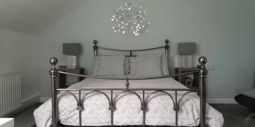 a bedroom with a black and white bed with two lamps at The Stables in Tregaron