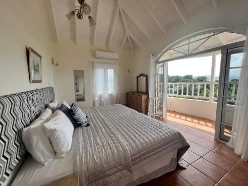 sypialnia z łóżkiem i dużym oknem w obiekcie Stunning 4-Bed Villa in Gros Islet St Lucia w mieście Bois dʼOrange