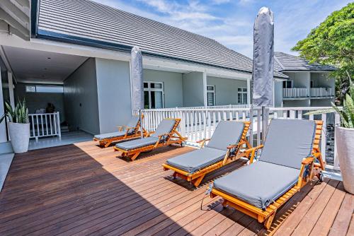 a row of lounge chairs on a wooden deck at Beach Wood Boutique Hotel & Resort in Ballito