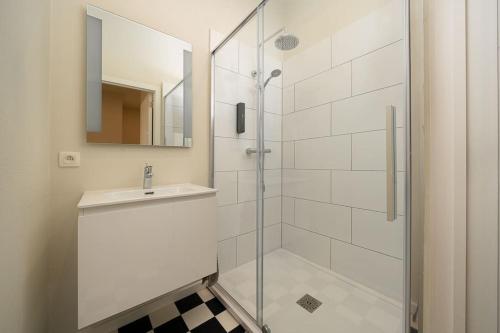 a bathroom with a shower and a sink and a mirror at Le calme en plein centre ville: Maison 4ch 4sdb in Liège