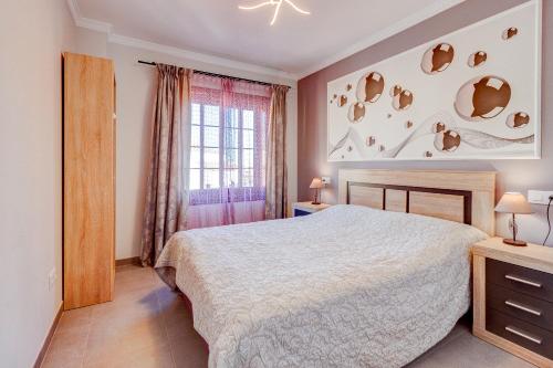 a bedroom with a bed and a window at Cozy two bedroom apartment in San Blas Golf del Sur Tenerife in San Miguel de Abona