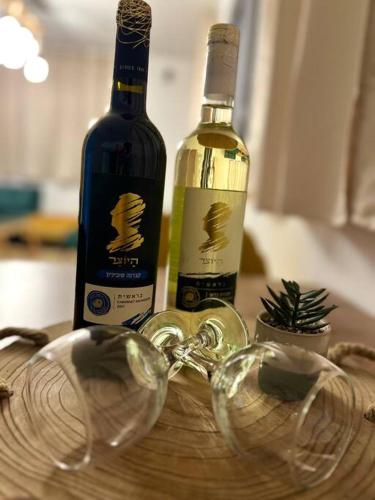 two bottles of wine and two glasses on a table at Deja Vu suite . Feel like Home in Majdal Shams