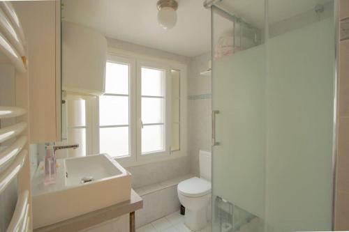 baño con lavabo y aseo y ventana en Au petit gnolles - 450m Métro - 100m Parc en París