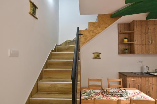 a staircase in a house with a table and chairs at Brvnara Mont 4 in Zlatibor