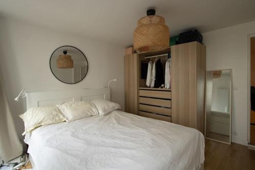 1 dormitorio con cama blanca y armario en Au petit gnolles - 450m Métro - 100m Parc en París