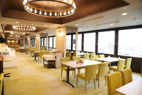 a restaurant with tables and chairs and windows at Niigata Toei Hotel in Niigata