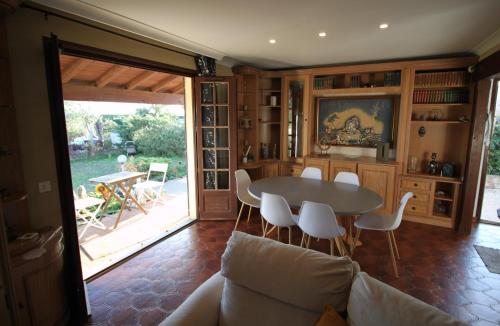 un salon avec une table et des chaises dans l'établissement La Maison de Georges - Climatisée -Terrain et vue Etang, à Marseillan