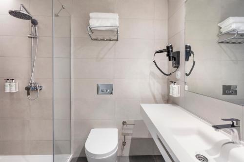 a bathroom with a toilet and a sink and a shower at B&B HOTEL Lisboa Oeiras in Oeiras