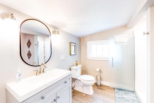 a bathroom with a sink and a toilet and a mirror at Summer Sliving in Orleans