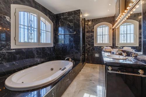 baño con 2 lavabos y bañera grande en Luxury Mediterranean Villa La Ladera, Marbella, en Benahavís