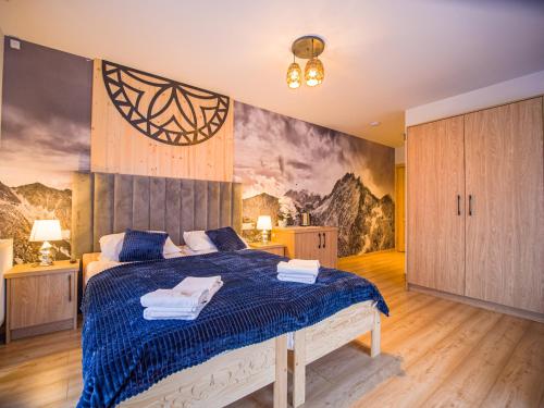 a bedroom with a bed with a blue comforter at Rezydencja Widokowa in Bukowina Tatrzańska
