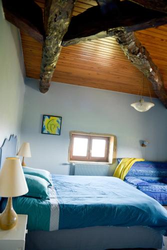 a bedroom with two beds and a wooden ceiling at La Grange du bois in Solutré-Pouilly