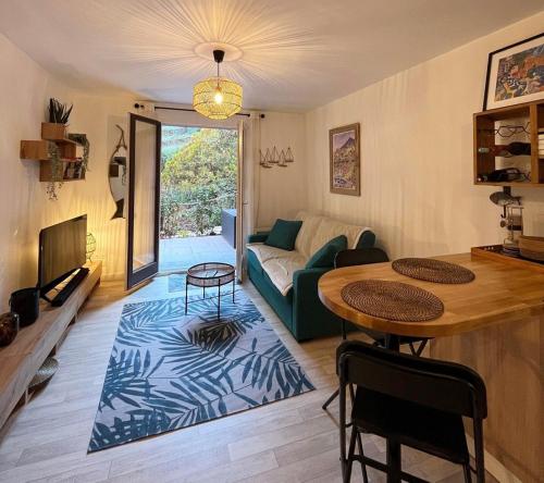 een woonkamer met een tafel en een bank bij 2TERIMP03 Superbe T2 neuf rez de chaussée avec 1 chambre et terrasse in Collioure
