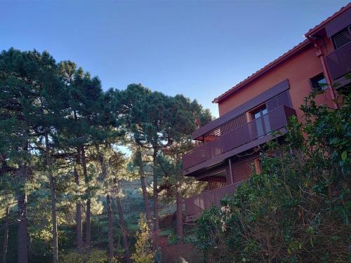 een gebouw aan de zijkant van een heuvel met bomen bij 2TERIMP03 Superbe T2 neuf rez de chaussée avec 1 chambre et terrasse in Collioure