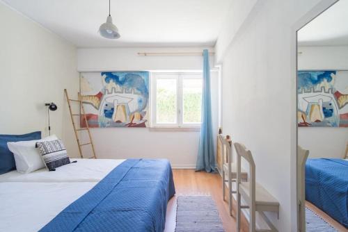 a bedroom with two beds and a window at Lisbon Waves Surf Lodge in Costa da Caparica