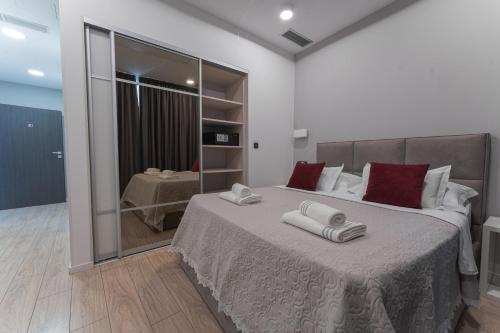 a bedroom with a large bed with two towels on it at Sky & Sun Luxury Rooms with private parking in the garage in Zadar