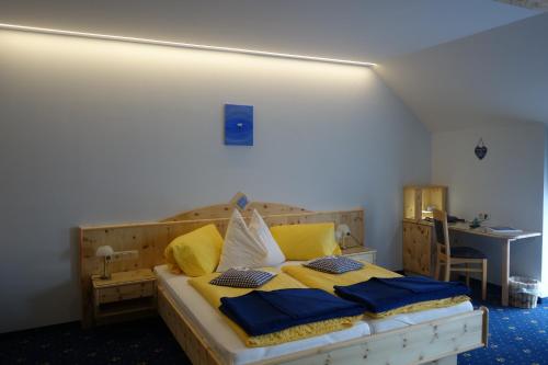 a bedroom with a bed with yellow and blue pillows at Edelsteinhotel Guniwirt in Krakaudorf
