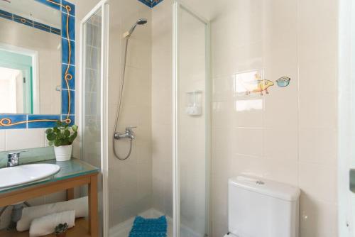 uma casa de banho com um chuveiro, um WC e um lavatório. em Lisbon Waves Surf Lodge em Costa da Caparica