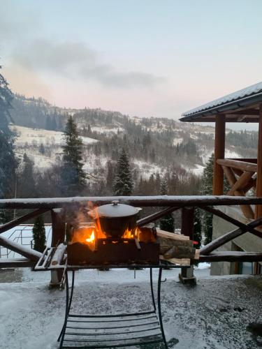 a fire pit in the snow on a porch at Край Неба in Slavske