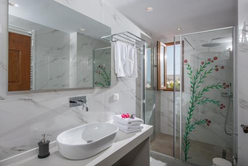 een witte badkamer met een wastafel en een douche bij Villa Greco in Chersonissos