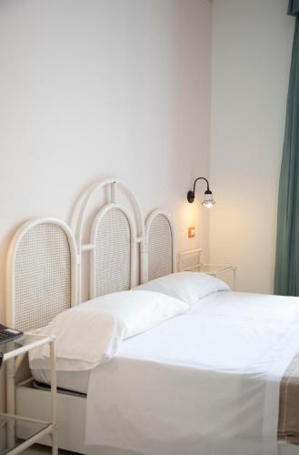 a bedroom with a white bed and a table at Hotel Loreley in Ischia