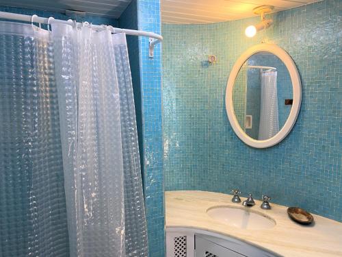 a bathroom with a shower with a sink and a mirror at Praia dos Ossos Guest House - Búzios com pé na areia in Búzios