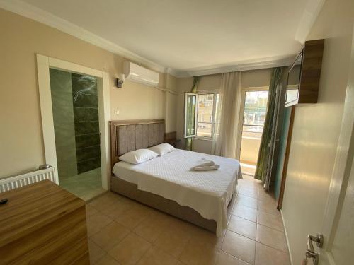 a bedroom with a bed and a glass shower at Vesta Apart Hotel in Kuşadası