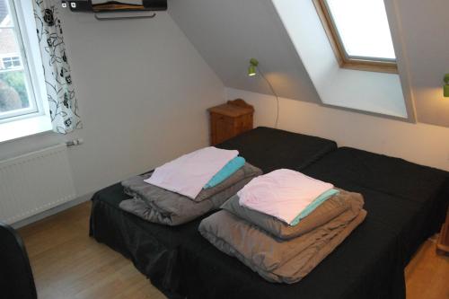 a bedroom with two beds with sheets and pillows at Postholderens sted in Guldborg