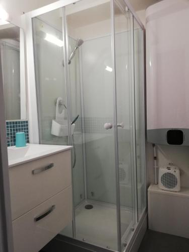 une douche avec une porte vitrée dans une salle de bain dans l'établissement sweet-home, à Seignosse