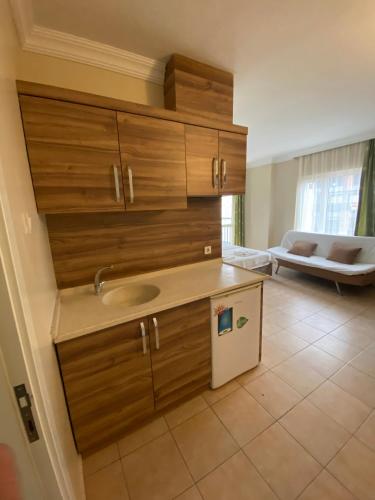 a kitchen with wooden cabinets and a sink at Vesta Apart Hotel in Kuşadası