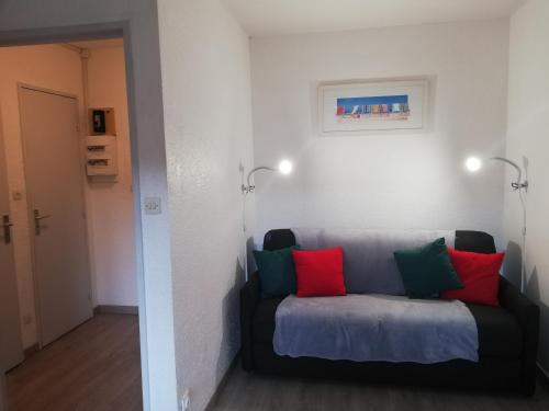 kanapa z czerwonymi i zielonymi poduszkami w pokoju w obiekcie sweet-home w mieście Seignosse
