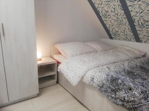 una piccola camera con letto e comodino di Apartament Stella a Duszniki Zdrój