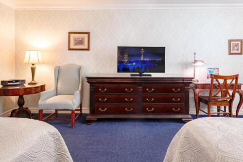 a hotel room with a television on a dresser at Red Coach Inn in Niagara Falls