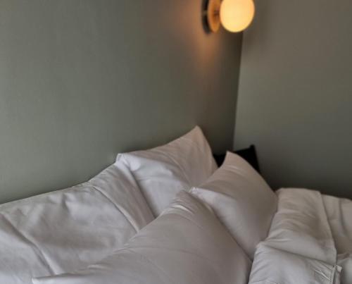 a bed with white sheets and pillows in a room at Rooftop Guesthouse Alvor in Alvor