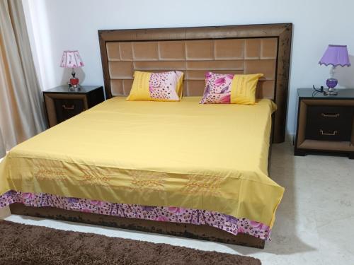 Hurghada Marina في الغردقة: غرفة نوم بسرير مع مخدات صفراء وردية