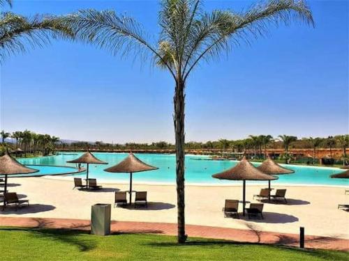 einen Strand mit Stühlen und Sonnenschirmen sowie einen Pool in der Unterkunft The Blyde Riverwalk Estate in Pretoria