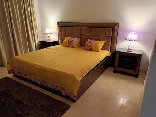 Hurghada Marina في الغردقة: غرفة نوم مع سرير مع مواقف ليلتين ومصباحين