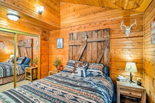 ein Schlafzimmer mit einem Bett in einem Blockhaus in der Unterkunft Cozy Manistique Cabin with Deck, Grill and Fire Pit! in Manistique